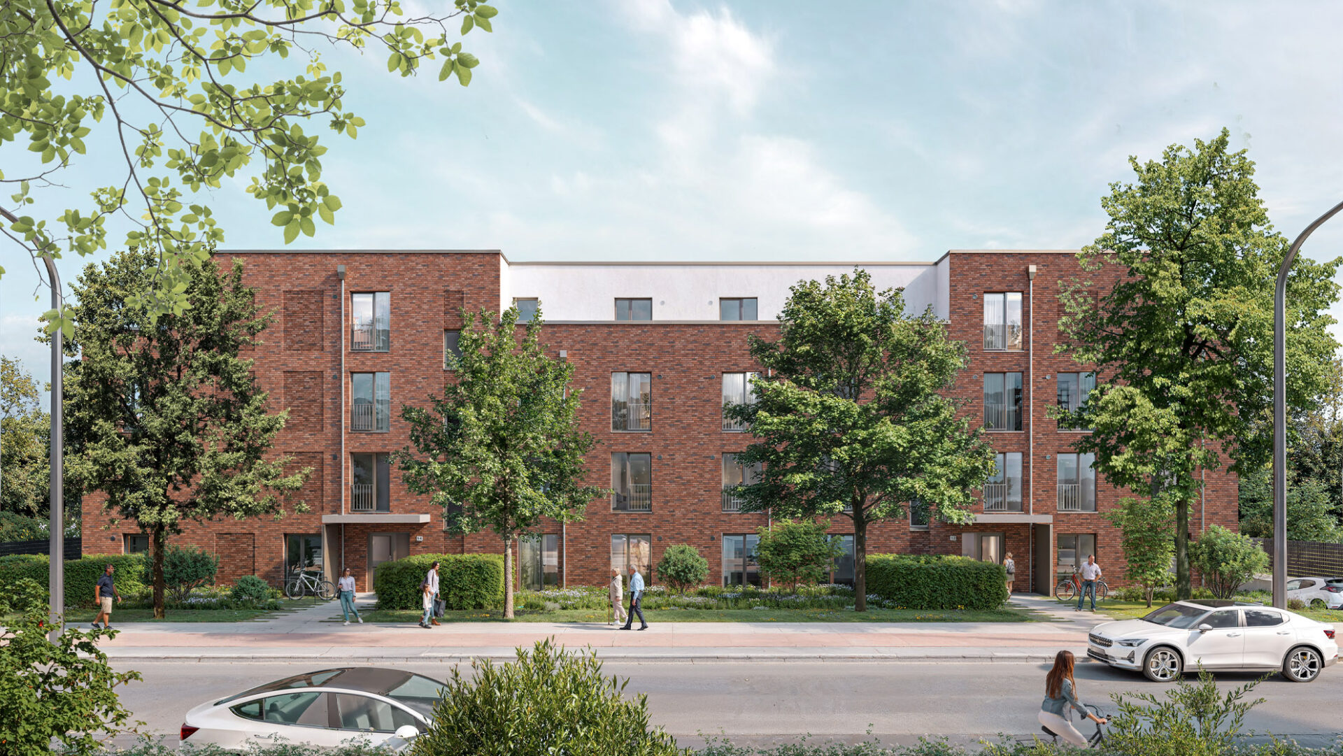 Ein modernes dreistöckiges Wohnhaus mit Eigentumswohnungen von Behrendt mit Staffelgeschoss, roten Klinkersteinen, großen Fenstern, Balkonen, Terassen, 2 Eingängen und 4 grünen Eichen davor. Frühlingshafter Himmel im Hintergrund und einer Straße mit Gehweg und Fahrradweg im Vordergrund.