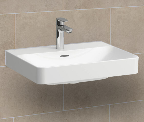 Ein modernes, rechteckiges, wandmontiertes Waschbecken aus weißer Keramik mit einem verchromten Wasserhahn vor einer beige gefliesten Wand - perfekt für eine stilvolle Hamburger Neubauwohnung.